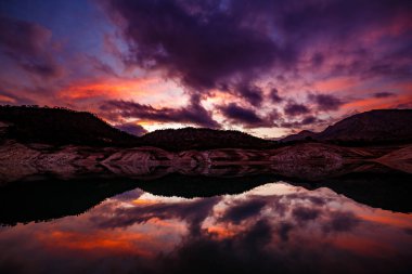Hills reflected in the Villajoyosa reservoir during sunset