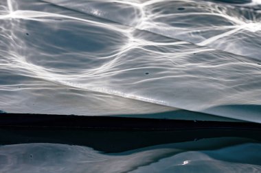 Villajoyosa limanındaki teknedeki deniz suyunun yansımaları.