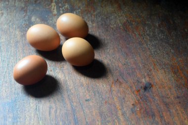 Yumurtalar kahverengi ahşap masada yatıyor.