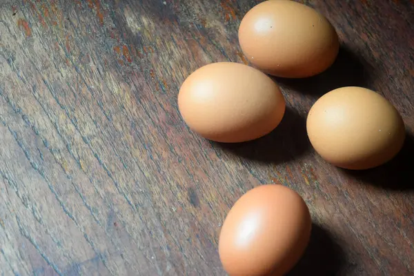 Kahverengi arka planda ahşap bir kutuda kahverengi tavuk yumurtası. Üst görünüm, boşluk kopyala.
