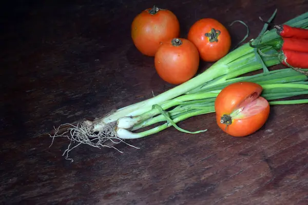 fresh red and white onions and tomatoes on a black background