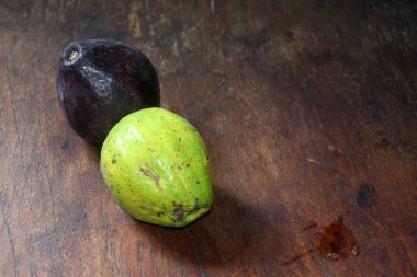 Ahşap arka planda taze yeşil mangosteen meyvesi.