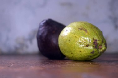 Tahta bir masada avokado ve patlıcan..