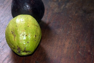 Tahta bir masada yeşil bir kakao kapsülünün yakın plan fotoğrafı.