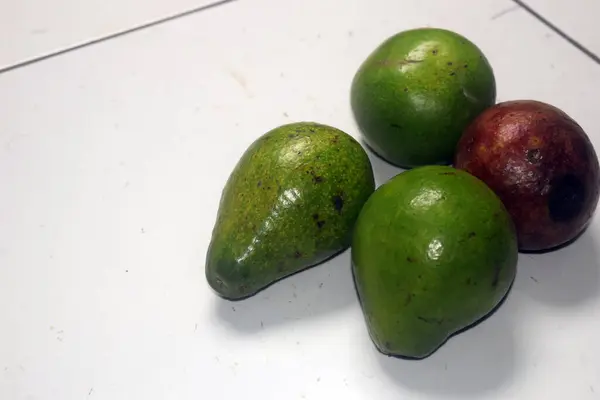 Beyaz arka planda avokado ve yeşil meyve