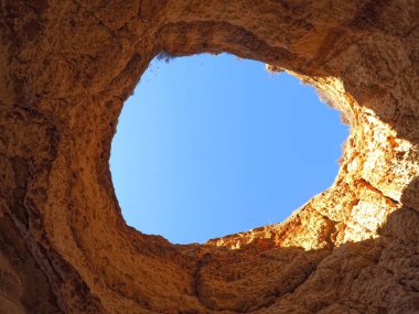 Bir uçurumda bir delik Algarve Portekiz 'deki mavi gökyüzüne bir manzara açar