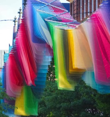 Gökkuşağı renginde bayraklar Almanya 'nın bir şehrinde rüzgarda dalgalanıyor.