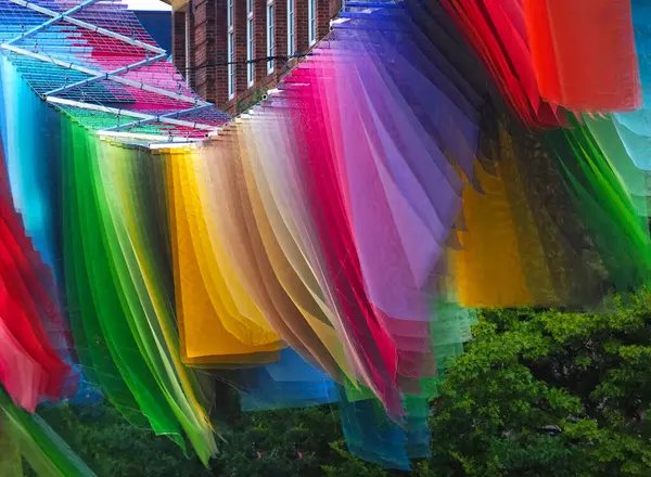 Gökkuşağı renginde bayraklar Almanya 'nın bir şehrinde rüzgarda dalgalanıyor.