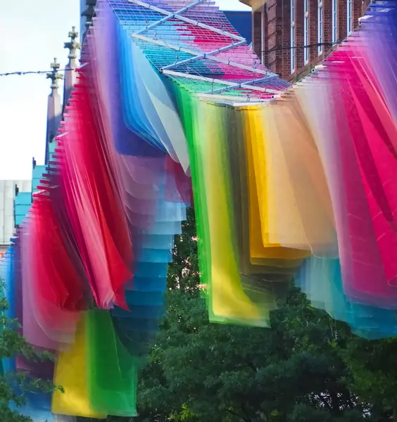 Gökkuşağı renginde bayraklar Almanya 'nın bir şehrinde rüzgarda dalgalanıyor.