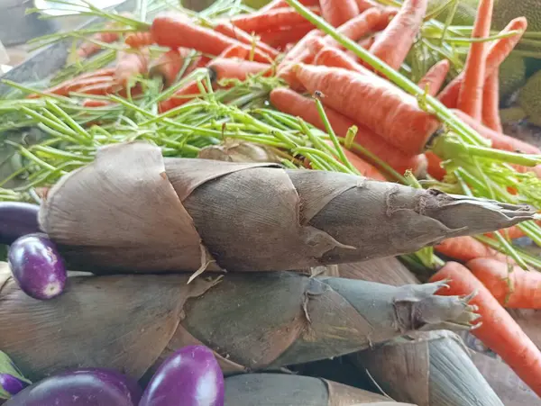 Bir markette taze bambu filizleri, havuçlar ve patlıcanlar.