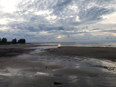 Low Tide 'da bir kumsal Bulutlu bir gökyüzü ve Uzak bir Ufuk