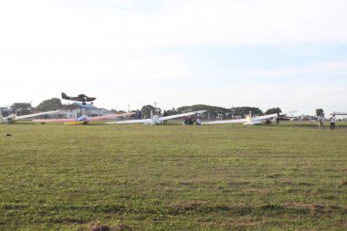 aceh, Endonezya - Eylül 1, 2024 Temiz bir gökyüzünün altında çimenli bir alana park etmiş küçük bir uçak grubu..