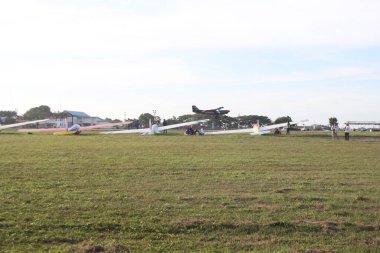 aceh, Endonezya - Eylül 1, 2024 Temiz bir gökyüzünün altında çimenli bir alana park etmiş küçük bir uçak grubu..