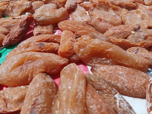 Kurumuş kayısıların yakın çekim görüntüsü bir yüzeye yayılır..