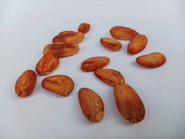 Temiz beyaz arka planda dağınık kavrulmuş kakao fasulyelerinin yakın plan görüntüsü..