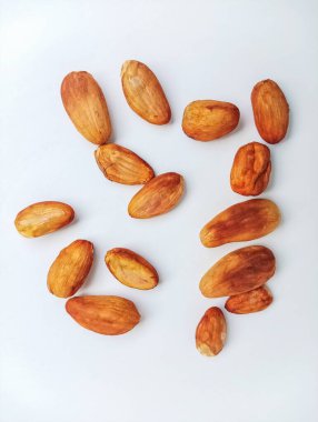 Temiz beyaz arka planda dağınık kavrulmuş kakao fasulyelerinin yakın plan görüntüsü..