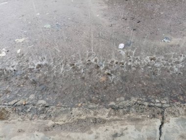 Yağmurla Öpülen Asfalt: Yağmur Damlaları ve Su birikintisinin Genel Görünümü