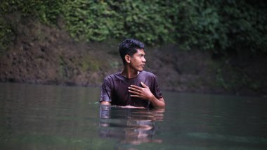 Koyu renk gömlekli adam Durgun Suya Yansıyan Adam, Yeşillik Ormanı Sırtı