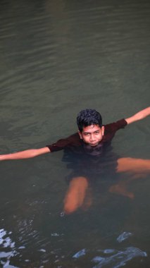 Genişletilmiş kollarıyla Bulanık Suda Yüzen Çocuk, Üst Görünüm