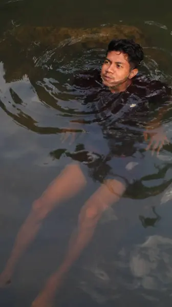 Bulanık suda yüzen adam, su altında görülebilir bacaklar, siyah bez.