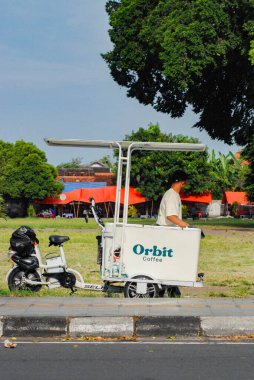 Yogyakarta, Endonezya - 30 Nisan 2025: Yogyakarta turistik bölgesinde kahve tezgahı, elektrikli araba bisikletiyle kahve satışı