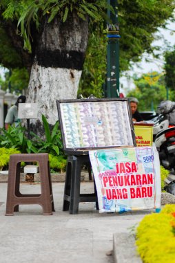 Yogyakarta, Endonezya - 8 Mayıs 2025: Yogyakarta şehrinin yol kenarında elle para değişimi hizmetleri, Endonezya 'da önemli anlarda yeni para alışverişi hizmetleri