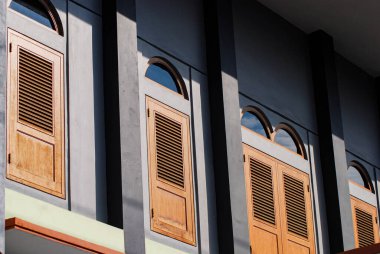 Eski moda şekilli ahşap pencereler, kahverengi ahşaptan yapılmış klasik ev kapıları, eski moda konseptli ev modelleri.