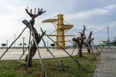 Destekli ağaçlar, sahil manzaralı deniz manzaralı ve şehir parkında yeşil çimenler.