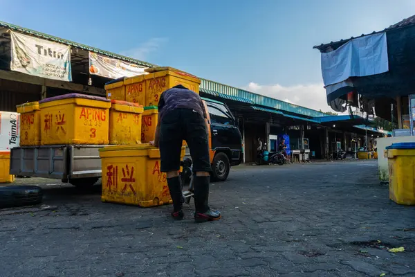 Tanjungpinang, Endonezya - 19 Şubat 2024: Pasar Bintan Merkezi olarak da bilinen Batu 9 Balık Pazarı 'ndaki bir kamyonetten balık kutuları yükleyip indiren kişi