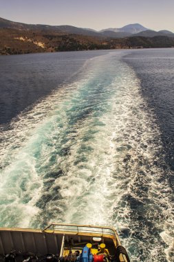 Bir geminin arkasında kıç dalgası bırakarak. Arkasında güzel bir kıyı şeridi bırakan bir geminin portre görüntüsü. Yüksek kalite fotoğraf