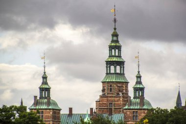 Orta Kopenhag 'daki Rosenborg Kalesi' nin bakır kuleleri. Arka planda dramatik kara bulutlar var. Yüksek kalite fotoğraf