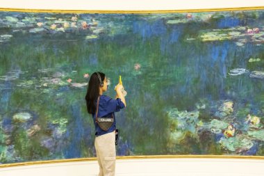 Paris, Fransa - 29 Temmuz 2022 Cuma: Monets Water Lillys ve Paris 'teki LOrangerie sanat galerisinde cep telefonuyla fotoğraf çeken bayan. Yüksek kalite fotoğraf