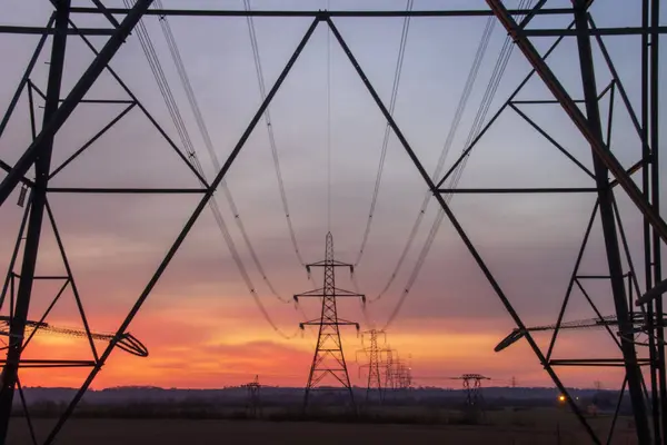 Elektrik direkleri güzel bir günbatımı gökyüzüne karşı siluetlendi. Yüksek kalite fotoğraf