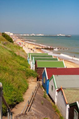 Southwold Beach Suffolk 'ta kulübeler ve uzaktaki rıhtım. Yüksek kalite fotoğraf