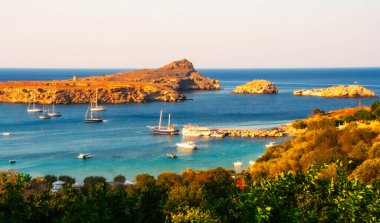Güneşli Rodos Yunanistan 'daki Lindos kayalık körfezinde altın öğleden sonra güneşinde tekneler. Yüksek kalite fotoğraf