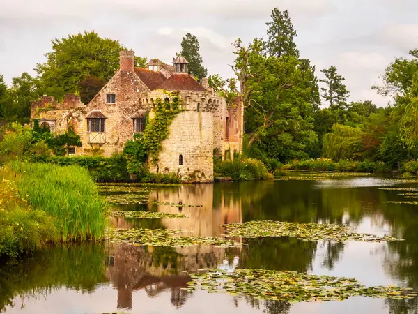 Tunbridge Wells, İngiltere - 20 Temmuz 2024 Cumartesi: Hendek gölünde yansımaları olan güzel taş Scotney Şatosu. Yüksek kalite fotoğraf
