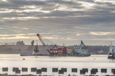 Dredging limanda çalışıyor. Toprağı kapar ve mavnaya yükler.