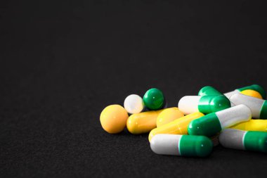 Tıbbi ilaçlar. Renkli kapsül ilaçları. Siyah arka plan. Sağlık hizmeti konsepti. Metin için boş alan. İlaçlar. Bir sürü farklı hap. Kimya endüstrisi.
