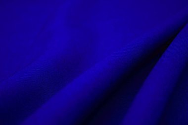 Mavi kumaş yakın plan. Pleksus iplikleri. Kıyafet endüstrisi. Soyut arkaplan. Tekstil dalgaları.