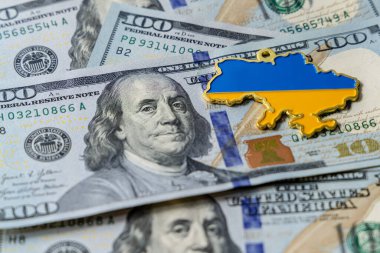 Yüz dolarlık banknotlar masaya saçıldı. Ukrayna haritası dolarların üzerinde. Birleşik Devletler 'in Ukrayna' daki finansmanı.