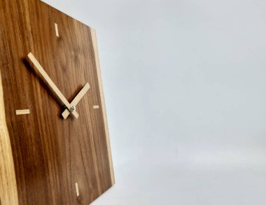 Tahtadan yapılmış bir duvar saati ve izole edilmiş beyaz bir arkaplan.