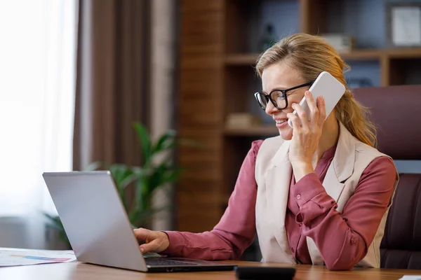 Retrato Mulher Negócios Sorrindo Falando Telefone Usando Laptop Interior Escritório — Fotografia de Stock