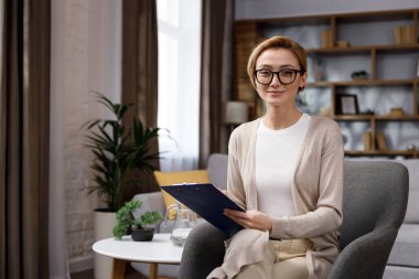 Güzel, gülümseyen, kendine güvenen, güzel yüzlü sarışın bir kadın kameraya bakıyor. Ofisteki psikolog ya da iş kadını, mutlu milenyum profesyonelleri ön portreyi yakın çekim