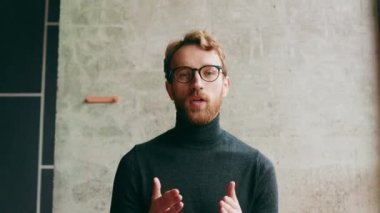 Genç, kızıl saçlı bir adam, şık bir kafede. Vlog kaydı, çevrimiçi video konferansı, video görüşmesi, çevrimiçi öğrenme, dersler, konferans. Röportaj, online eğitim. Web kamerasından görüntüle