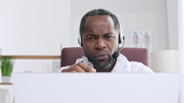 非裔美国男性医生欢迎使用笔记本电脑进行在线病人咨询 提供远程医疗服务的办公室 在线医疗和远程医疗概念 — 图库视频影像