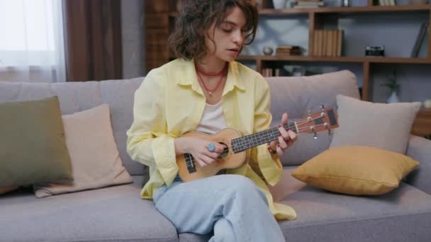 Sarı Tişörtlü Güzel Bir Hippi Kız Evdeki Kanepede Gitar Çalıp — Stok video