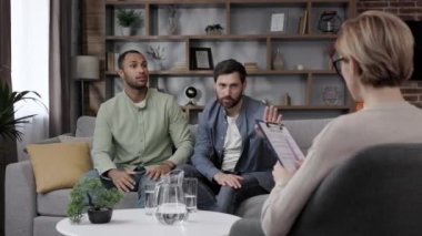 LGBT family at a psychotherapists appointment. A family psychologist conducts a session in a beautiful office. Psychologist for gay. Support for the LGBT community on a visit to a psychologist
