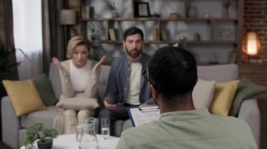 A quarrel between a husband and wife at a psychotherapists appointment. A visit to a family psychologist for a married couple. An African-American doctor consults an unhappy couple