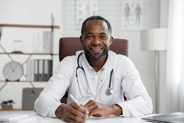 African American male doctor welcomes online patient consultation in laptop. An office providing telemedicine services. online medicine and telemedicine concept