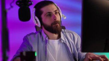 Close-up portrait of an esportsman. A professional gamer plays a computer video game, communicates in a headset with a team at the E-Sport championship. cyber gaming arena